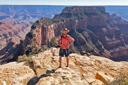 A hiker stands proudly in front of a part of the canyon.